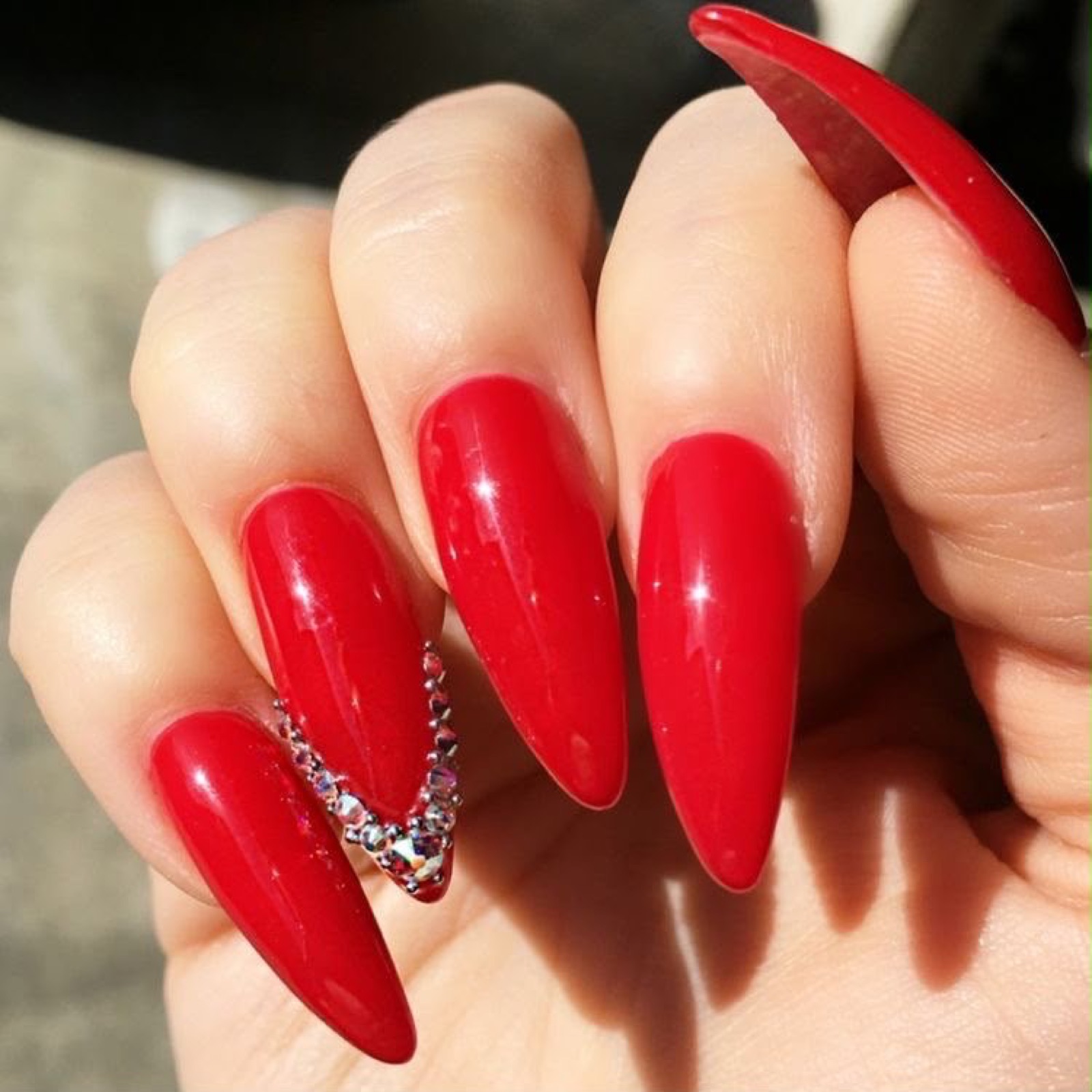 Red almond nails with crystal accent