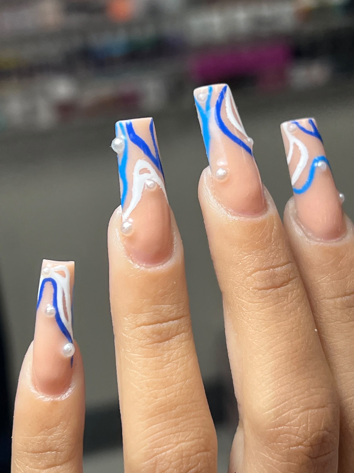 Blue and white abstract nail art with pearls